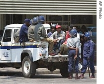 Riot police keep an eye on detained protesters after they were arrested in Harare 