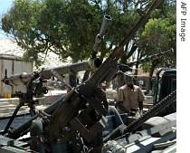 A Somali boy sits near different heavy caliber guns returned by different warlords in Mogadishu