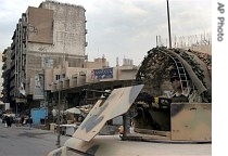 An Iraqi army soldier mans a machine gun atop a Humvee while securing a street in Baghdad, Iraq, as part of the new security sweep