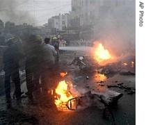 Firefighters hose down burning vehicles following an explosion in a crowded commercial area near the Imam Hussein shrine in Karbala, Iraq 28 Apr 2007