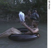 At dusk, illegal immigrants prepare to use an inner-tube to cross the Rio Grande River at the U.S-Mexico border in Nuevo Laredo, Mexico, 02 June 2007