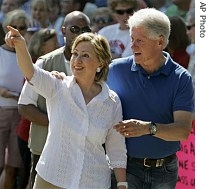 Former President Bill Clinton talks to his wife, Democratic presidential hopeful US Senator Hillary Clinton as she acknowledges supporters at the Fourth of July Parade Wednesday in  Clear Lake, Iowa, 4 July 2007