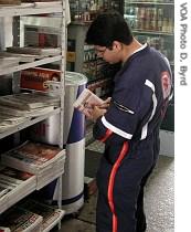 An EMT worker reads about the crash at a local newsstand