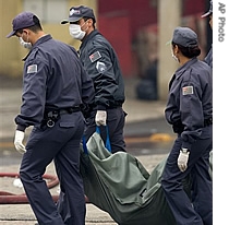 Police officers carry remains of victims from the crash of a TAM airlines commercial jet in Sao Paulo, 18 July 2007