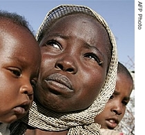 A displaced Sudanese woman carries her sons in the Otach Displaced Persons camp in the city of Nyala in Sudan's strife-torn Darfur region, (File)