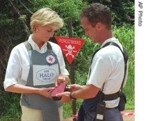 Princess Diana uses a remote switch to trigger the detonation of some explosive ordinance dug up by mine sweepers in Huambo, Angola, 15 Jan 1997