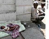 One-week-old Dastgeer lies on a footpath as his father Shakeel Khan begs with his other son Saleem, right, outside a shrine in Bangalore, India 