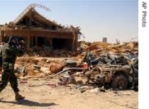 Iraqi soldier videotapes the ruins of a coordinated suicide attack in the town of Qahataniya, 15 Aug 2007