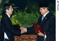 Japanese Prime Minister Shinzo Abe (l) and Indonesian President Susilo Bambang Yudhoyono shake hands after the signing ceremony of a bilateral free trade agreement, 20 Aug 2007