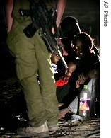 A Sudanese refugee family in front of an Israeli soldier after crossing illegally from Egypt into Israel, 20 Aug 2007