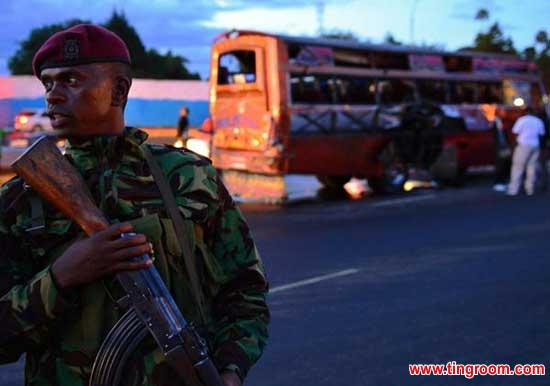 A Kenyan policeman stands in front of the wreckage of a bus at the site of a bomb blast in Nairobi on May 4, 2014. 