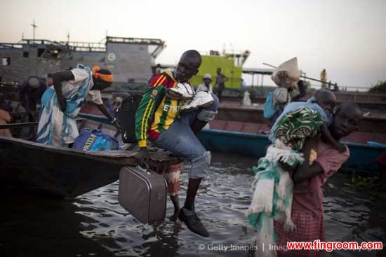 Internally displaced persons cross the Nile river to get to Minkamman, on March 1, 2014. 