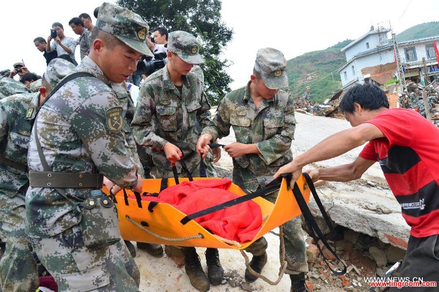 Rescuers transfer an injured person in quake-hit Longtoushan Township of Ludian County, southwest China