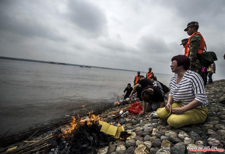 Relatives of the victims of the capsized ship Eastern Star mourn at the bank of the Jianli section of the Yangtze River, central China