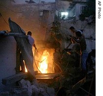 Residents try to extinguish the fire at the site of a Hezbollah rocket attack in the northern Israel coastal town of Haifa