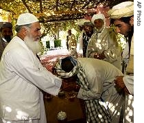 Supporter, center, kisses and shows his respect at the western stronghold of a regional warlord and former governor of Herat, Ismail Khan, left, during meeting in his residence in Herat in Afghanistan (File photo) 