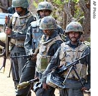 Government soldiers patrol on the Mavilaaru reservoir tank bank in Mavilaaru, close to Muttur, Sri Lanka, Monday, August 28, 2006