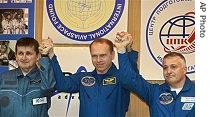 Russian cosmonaut Oleg Kotov, center, U.S. billionaire Charles Simonyi, left, and Russian cosmonaut Fyodor Yurchikhin, right, gesture after a news conference at the training center in Baikonur, Kazakhstan, 6 Apr 2007