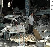 A man stands among the carnage after a pickup truck loaded with artillery shells exploded in the town of Mahmoudiyah, Iraq, 08 Apr 2007