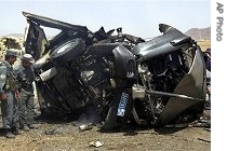 Afghan police officers check the destroyed United Nation's vehicle after it was hit by a road side bomb in the main city of Kandahar province, 17 Apr 2007