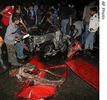 Palestinians check the damage of the destroyed car of Islamic Jihad militant, Kamal Anan, after it was hit by an Israeli air strike at Jabaliya refugee camp, northern Gaza Strip