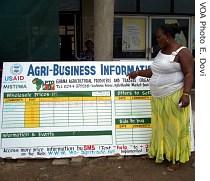 A vegetable seller Dorothy Quaye uses her cell phone to check current prices