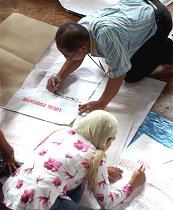 Public school teachers tally the votes on the floor during canvassing of votes for Monday's local election held in a gymnasium at Marawi city, Lanao Del Sur province in southern Philippines, 15 May 2007