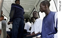 A Senegalese policeman loads young would-be migrants into a van on their arrival at the port of Dakar, Senegal Thursday, Thursday 26 April 2007